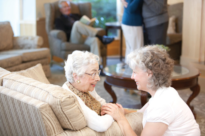 Nurse comforting senior woman in retirement home